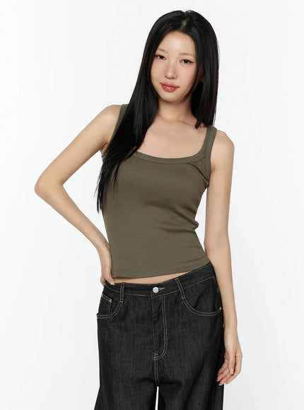 Ribbed Slim Tank Top IL516 Dark brown three-quarter front model shot smiling with hand on hip showing fitted silhouette paired with black wide-leg denim