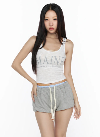 LEWKIN Ribbed Tank Top CL527 White front view on model, cropped ribbed knit tank with MAINE graphic print, paired with gray drawstring shorts, S/M