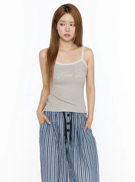 Ribbed Two-Tone Cami Top CL502 beige front model shot with hands in pockets, styled with blue striped wide-leg pants, relaxed pose