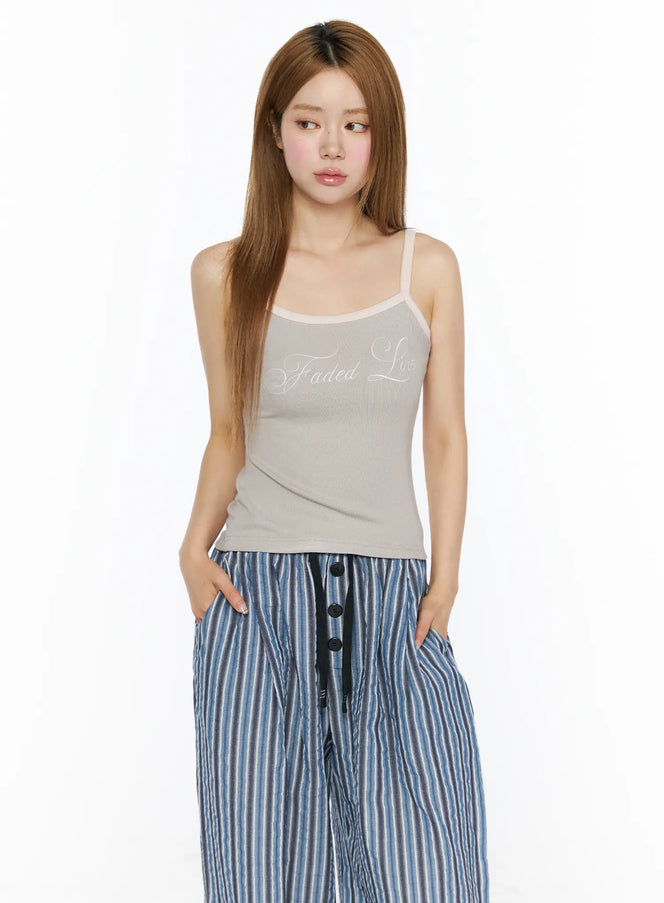 Ribbed Two-Tone Cami Top CL502 beige front model shot with hands in pockets, styled with blue striped wide-leg pants, relaxed pose