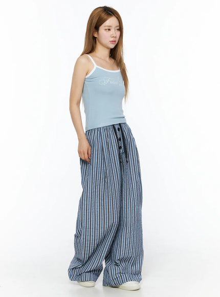 Ribbed Two-Tone Cami Top CL502 Light blue side model shot angled left, ribbed knit texture, white contrast trim, paired with blue striped wide pants