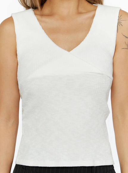 Ribbed Wrap Tank Top IL524 White close-up detail shot on model, V-neck crossover wrap bust construction, ribbed knit fabric texture clearly visible, sleeveless crop fit