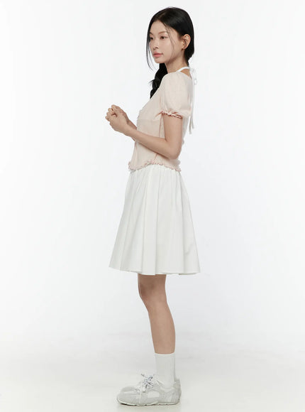 Ribbon Detail Puff Short Sleeve and Halter Set IL506 Light pink side view on model hands clasped showing back halter tie ribbon detail ruffled cuff and pointelle knit texture