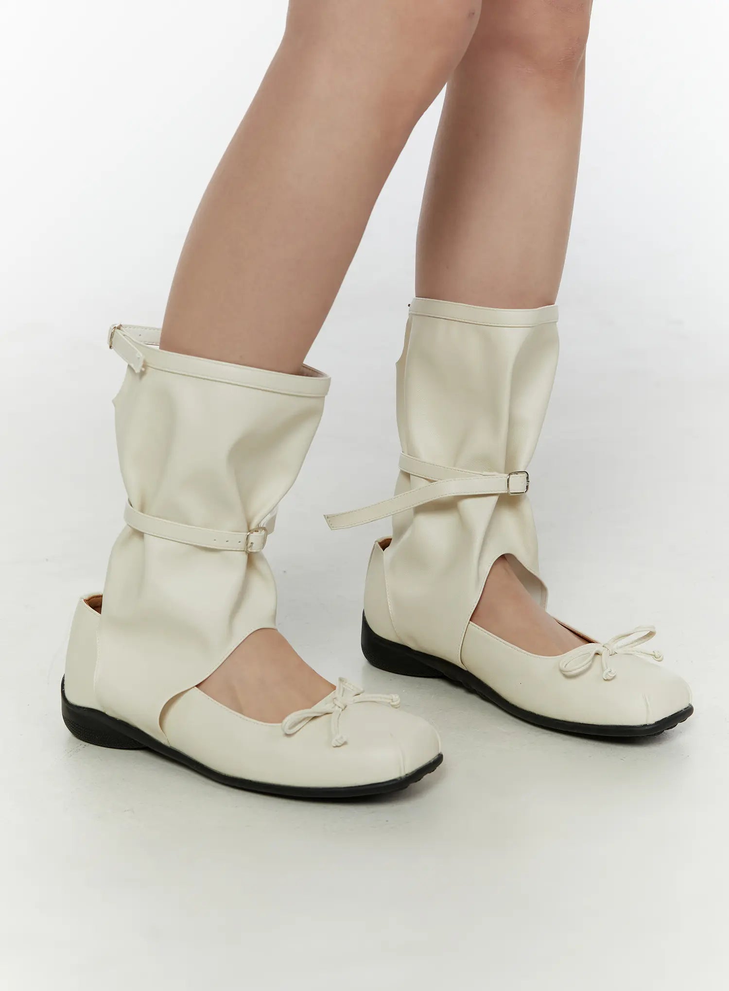 Ribbon Flat Ankle Boots CL507 Light beige side angle view on model showing slouchy gaiter shaft buckle ankle strap and bow toe in faux-leather