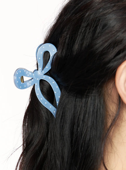 Ribbon Hair Pin IL514 blue worn on model styling dark hair in half-up look close-up showing polka dot bow claw clip at side