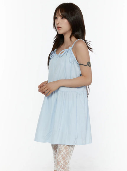 Ribbon Mini Dress CL508 Light blue side shot on model with hands clasped, tiered flowy skirt and relaxed fit, styled with lace tights