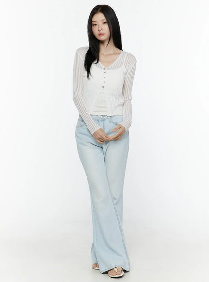 Ripley Light Washed Flared Jeans IL506 Light blue full-length front shot on model in white sheer cardigan hands clasped standing upright showing full flared leg length