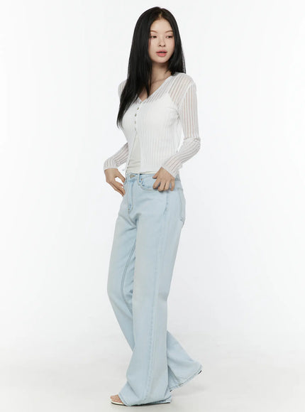 Ripley Light Washed Flared Jeans IL506 Light blue side shot on model in white sheer ribbed cardigan hand on hip showing flared silhouette and full length