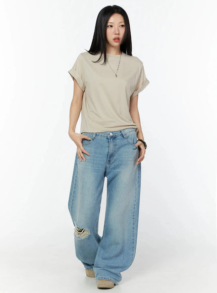 Rolled Cuff Loose Tee IU524 Beige full-body front shot on model hands in pockets, necklace, ripped wide-leg jeans, neutral background