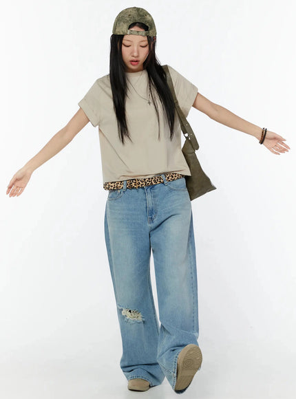 Rolled Cuff Loose Tee IU524 Beige full-body front shot on model arms outstretched, styled with ripped wide-leg jeans, leopard belt, shoulder bag