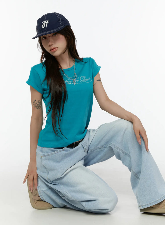 LEWKIN Rolled-Up Graphic Slim Fit Tee CL507 Blue S/M model crouching front shot rhinestone Born To Glow script tee styled with wide-leg jeans and navy cap