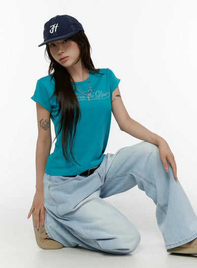 LEWKIN Rolled-Up Graphic Slim Fit Tee CL507 Blue S/M model crouching front shot rhinestone Born To Glow script tee styled with wide-leg jeans and navy cap