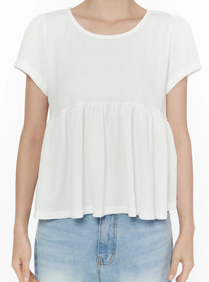 Round Neck Shirred Short Sleeve Top CL520 White close-up detail shot on model showing crinkle fabric bodice empire waist seam and flared shirred hem