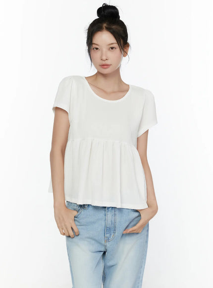 Round Neck Shirred Short Sleeve Top CL520 White close-up front shot on model highlighting smocked bodice texture gathered peplum hem and round neckline detail