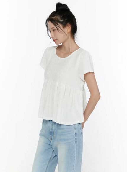 Round Neck Shirred Short Sleeve Top CL520 White side shot on model highlighting relaxed cap sleeve gathered peplum waist and flowy crinkle fabric texture