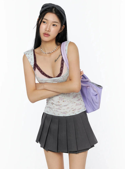 Ruched Bow Headband IL509 Dark gray three-quarter view on model styled with floral tank, gray pleated mini skirt, and lavender shoulder bag, arms crossed