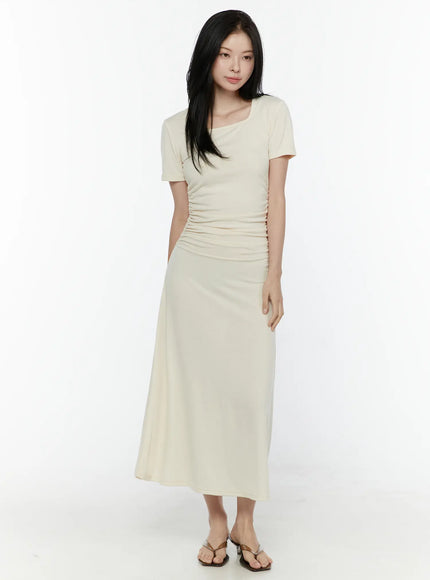 Ruched Maxi Dress IL506 Light beige front full-body model shot standing upright showing square neckline side ruching and maxi A-line skirt with thong sandals