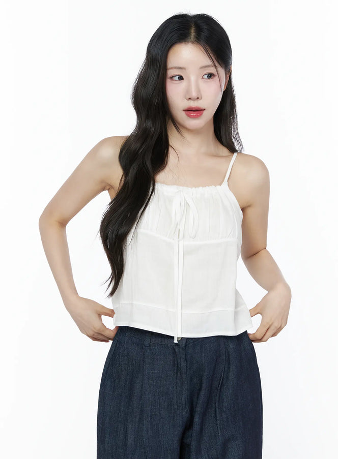 LEWKIN Ruched Ribbon Cami Top IU525 White S/M front crop shot on model hands on hips showing gathered neckline tie detail with sheer layered fabric