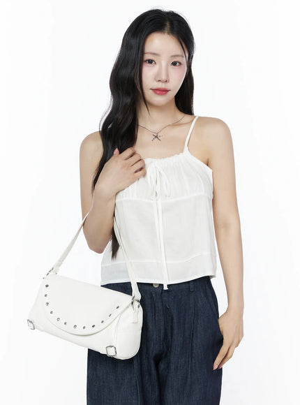 Ruched Ribbon Cami Top IU525 White half-body front shot on model holding white studded shoulder bag necklace styled with dark denim wide-leg trousers