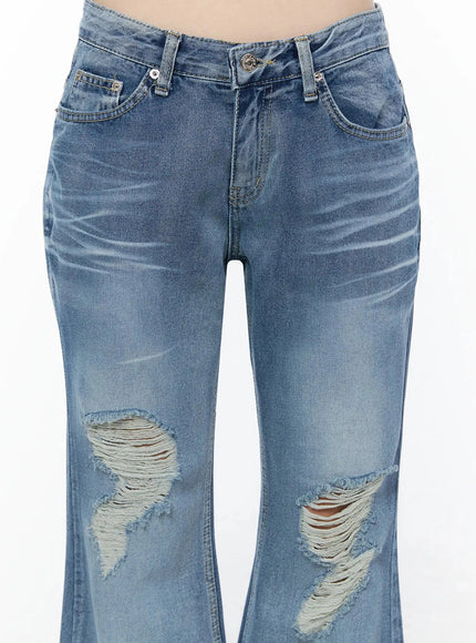 Rue Distressed Bootcut Flare Jeans IU525 Blue close-up detail shot showing waistband, front pockets, silver hardware, and frayed knee distressing