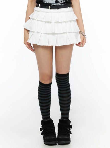 LEWKIN Ruffle Detail Mini Skirt IL523 White front close-up on model wearing S size with black belt, three-tier pleated texture, styled with striped knee socks