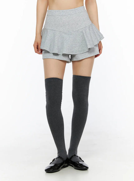 Ruffle Hem Mini Skort CL502 Gray S front model shot waist-down showing layered ruffle hem built-in shorts and dark over-the-knee socks with patent flats