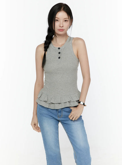 Ruffle Hem Tank Top IL506 Grey front shot on model standing, ribbed knit sleeveless top with three black buttons at crew neck and double layered ruffle hem, styled with blue jeans