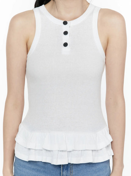 Ruffle Hem Tank Top IL506 White close-up front shot on model torso, detail of three black buttons at crew neckline, ribbed knit texture and double layered ruffle hem