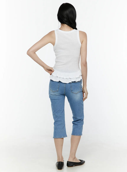 Ruffle Hem Tank Top IL506 White back shot on model standing with hand on hip, showing ribbed knit back panel and double tiered ruffle hem, paired with cropped blue jeans