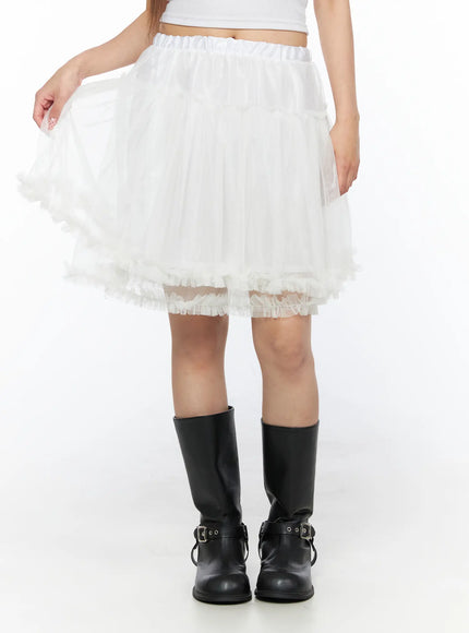 Ruffle Layered Midi Skirt CL517 White front shot on model lifting skirt hem to show tulle volume tiered layers and frayed ruffle trim with black boots