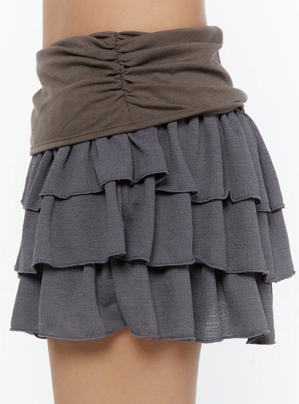 Ruffle Layered Mini Skirt CU529 Brown close-up side detail showing ruched brown fold-over waistband and gray three-tiered ruffle layers with raw lettuce-edge hem texture