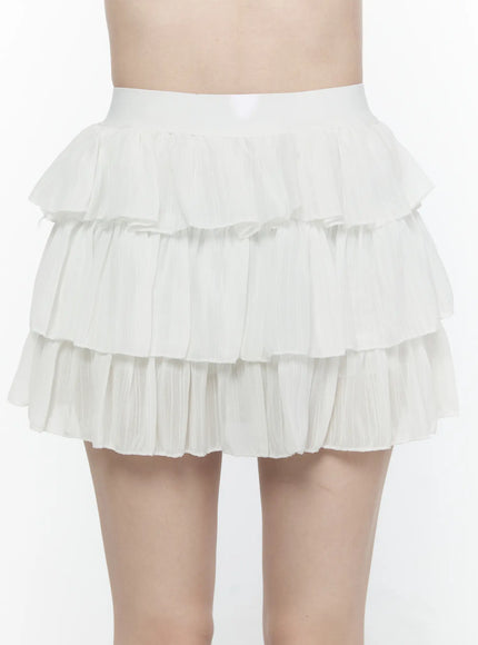 Ruffle Layered Mini Skirt IL521 White close-up front view on model showing three-tier pleated chiffon ruffle texture and wide elastic waistband