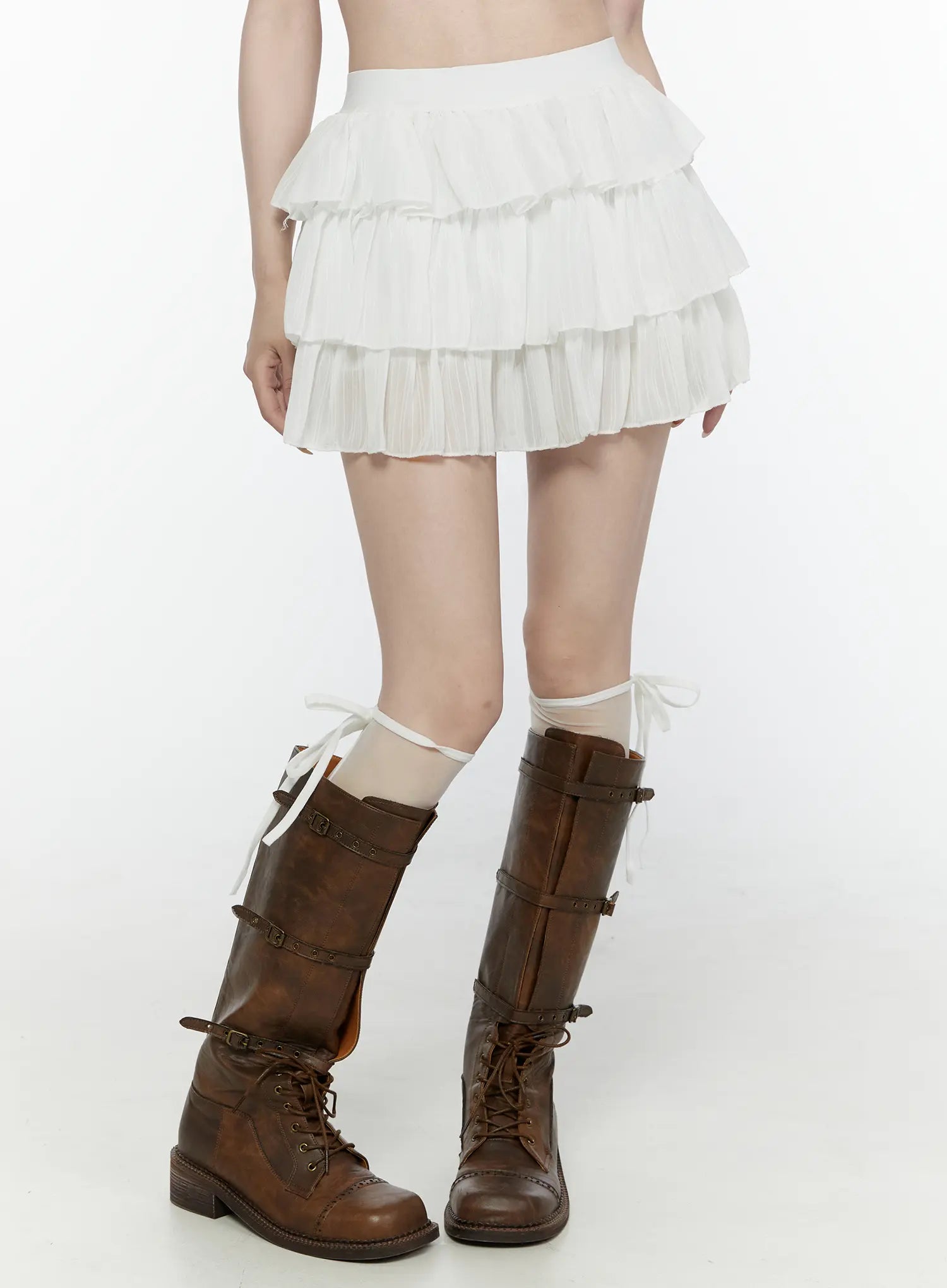 Ruffle Layered Mini Skirt IL521 White front detail view on model showing pleated ruffle tiers and elastic waistband, styled with brown buckle boots