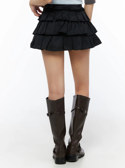 Ruffle Layered Mini Skirt IL523 Black back model crop shot showing three-tier pleated back view with leather belt and knee-high boots