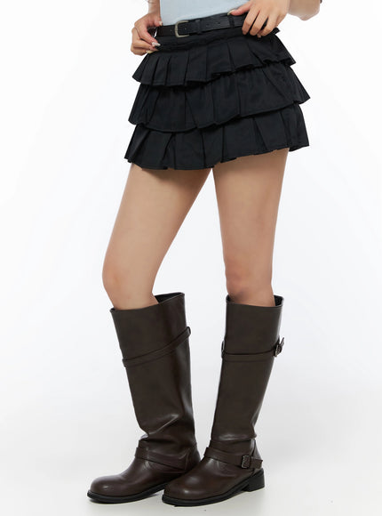 Ruffle Layered Mini Skirt IL523 Black side model crop shot model adjusting belt at waist showing tiered pleated layers paired with knee-high boots