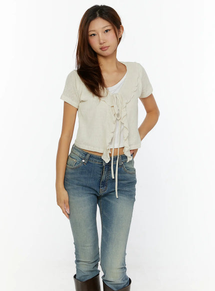 Ruffle Tie Cardigan CL515 cream front shot on model wearing jeans and tall brown boots, ruffle V-neck tie closure soft knit crop cardigan