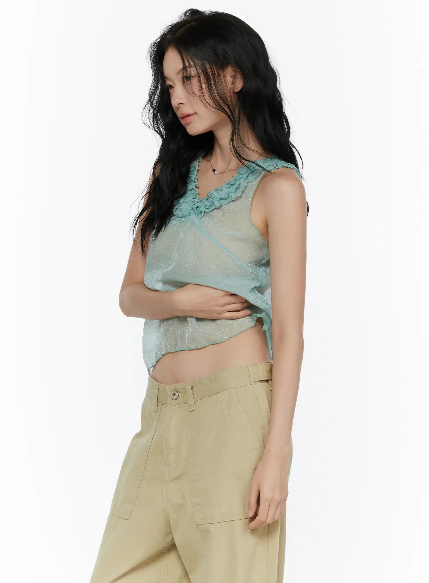 Ruffle V-Neck Sleeveless Top CL521 Mint side shot on model arms crossed showing sheer glitter cropped silhouette and ruffle neckline from side angle