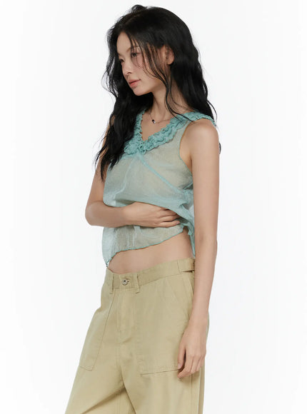 Ruffle V-Neck Sleeveless Top CL521 Mint side shot on model arms crossed showing sheer glitter cropped silhouette and ruffle neckline from side angle