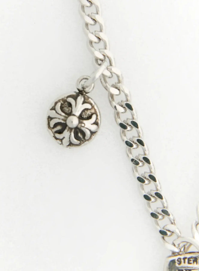 Shadow Sword Necklace IL522 Silver detail of floral medallion charm and curb chain link clasp area on white background