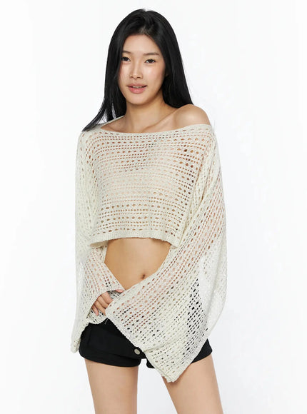 Shawl Crop Knit Top IL506 Light beige three-quarter front model smiling hands at sides showing open-knit shawl drape off-shoulder neckline and cropped length