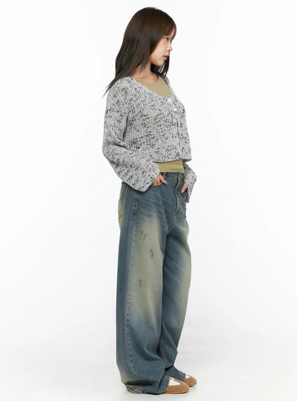 Sheer Knit Cardigan CL517 Gray side shot on model facing left, showing cropped length and flare sleeves of speckled open-knit over olive tank