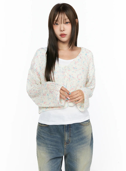 Sheer Knit Cardigan CL517 White front shot on model with hands clasped, open cardigan with multicolor speckle knit over white tank and denim