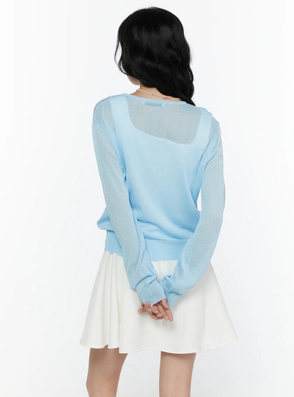 Sheer Knit Cropped Cardigan CL520 Light blue back shot on model showing sheer knit back panel ribbed hem and label over white mini skirt