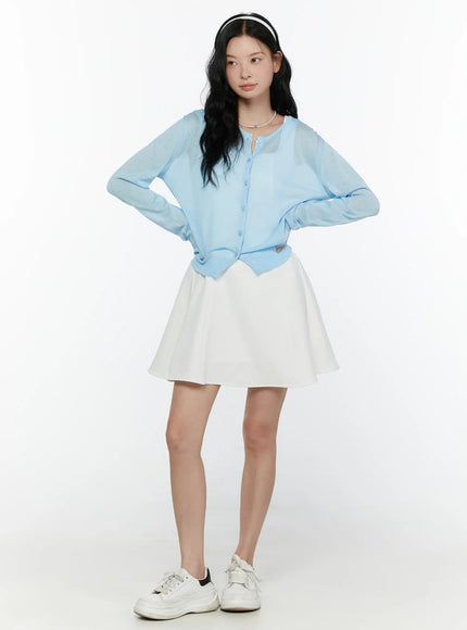 Sheer Knit Cropped Cardigan CL520 Light blue full-body shot on model hands on hips with white flare skirt and white sneakers