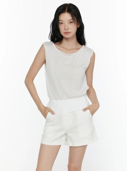 Sheer Knit Sleeveless Top CL521 White close-up front shot on model hands in pockets showing sheer knit texture and ribbed hem waistband