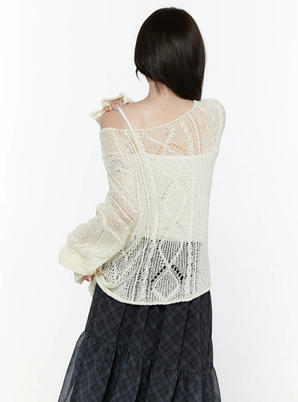Sheer Knit Top IL522 Light beige back shot on model showing open-knit lace pattern across back with off-shoulder detail and frilled sleeve cuffs over dark plaid skirt