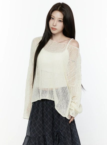 Sheer Knit Top IL522 Light beige front three-quarter crop shot on model with off-shoulder spaghetti strap visible showing open-weave knit pattern and semi-transparent fabric over skirt