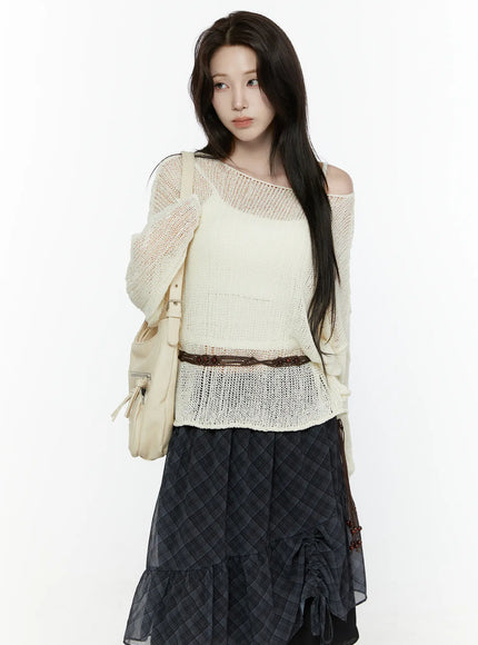 LEWKIN Sheer Knit Top IL522 Light beige three-quarter crop shot on model wearing open-shoulder style with cami underneath layered over dark plaid skirt with backpack