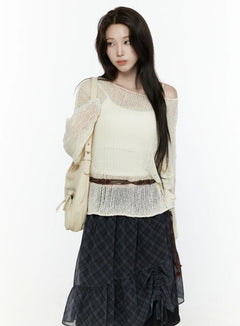 LEWKIN Sheer Knit Top IL522 Light beige three-quarter crop shot on model wearing open-shoulder style with cami underneath layered over dark plaid skirt with backpack