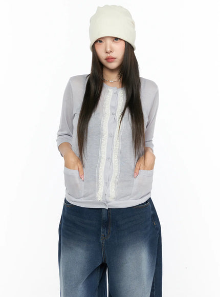 Sheer Lace Detail Cardigan CL514 gray front model shot with lace trim button placket hands in pockets paired with wide-leg denim